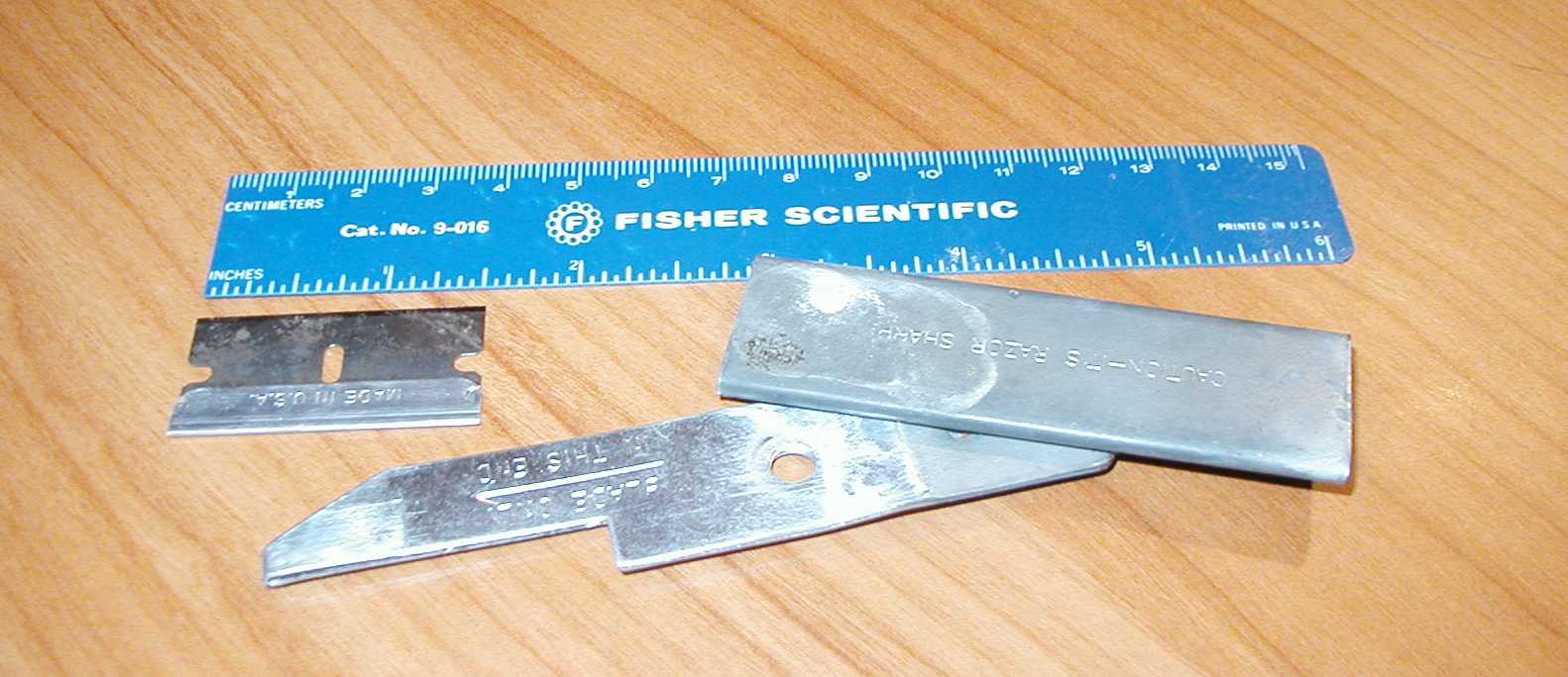 A box cutter disassembled, with razor out.